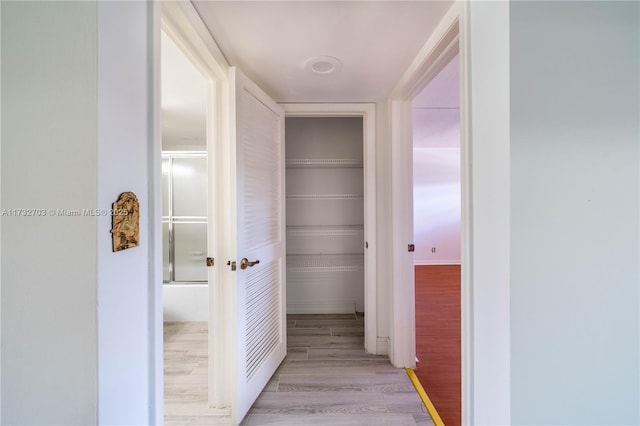 hallway with light hardwood / wood-style floors