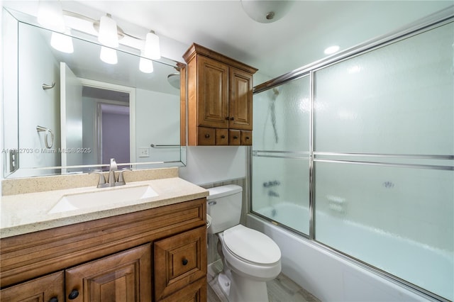 full bathroom with vanity, enclosed tub / shower combo, and toilet