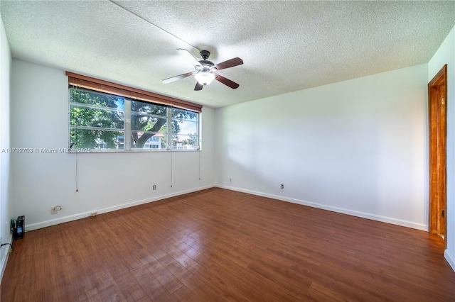 empty room with ceiling fan, dark hardwood / wood-style floors, and a textured ceiling