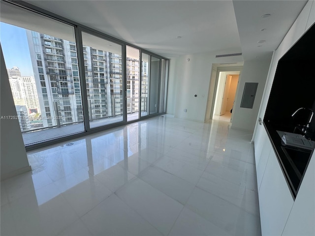 unfurnished room featuring a wealth of natural light, electric panel, expansive windows, and light tile patterned flooring