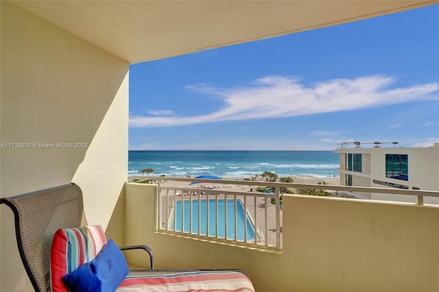 balcony featuring a water view and a view of the beach