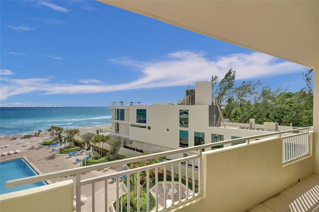 balcony with a water view and a view of the beach