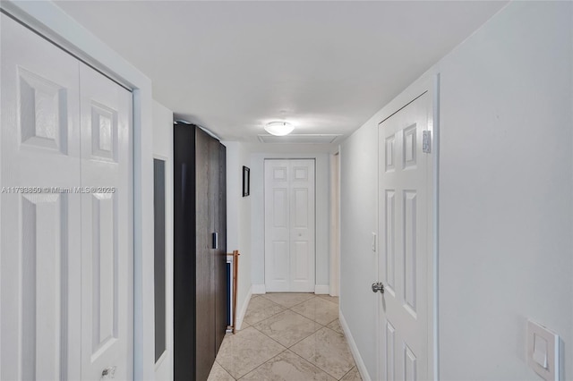 corridor featuring baseboards and marble finish floor