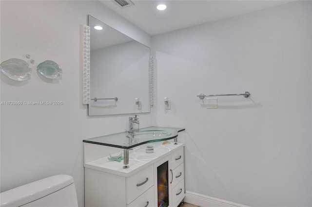 bathroom with vanity, recessed lighting, visible vents, and toilet