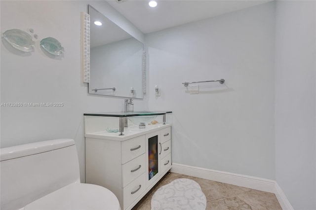 bathroom featuring vanity, toilet, baseboards, recessed lighting, and tile patterned floors