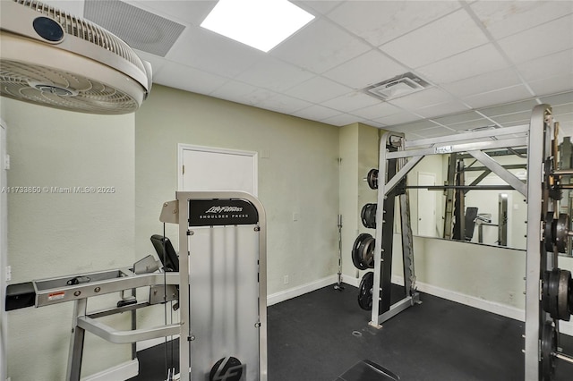 exercise room featuring baseboards, visible vents, and a drop ceiling