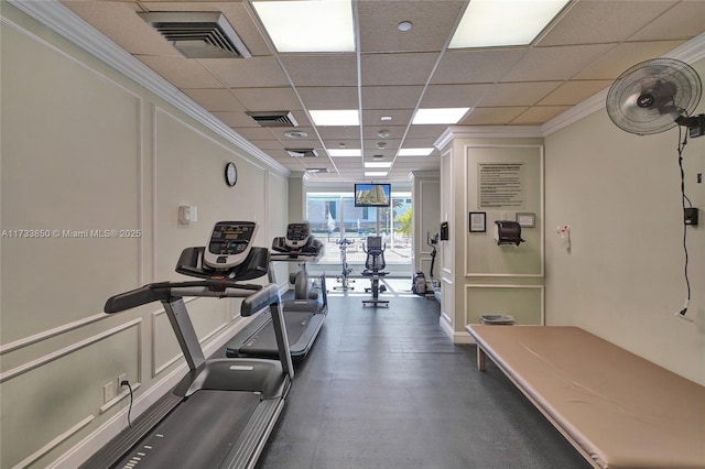exercise room featuring a decorative wall, ornamental molding, a drop ceiling, and visible vents