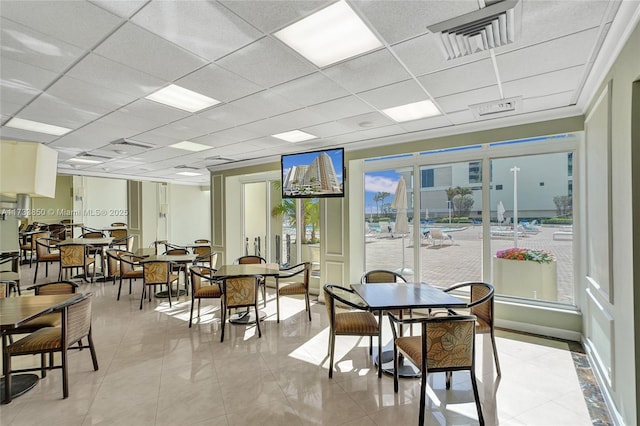 tiled dining area featuring a paneled ceiling