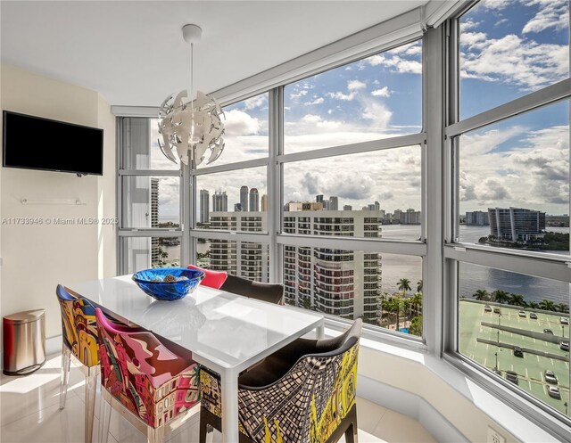 tiled dining area with a water view and an inviting chandelier