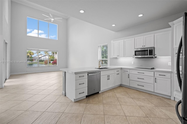 kitchen featuring appliances with stainless steel finishes, white cabinets, and decorative backsplash