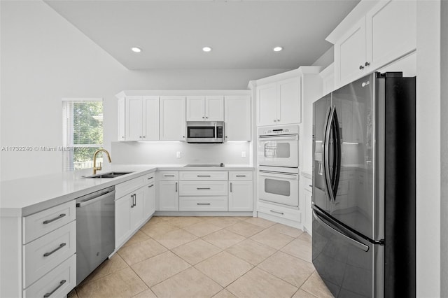 kitchen featuring sink, light tile patterned floors, stainless steel appliances, and white cabinets