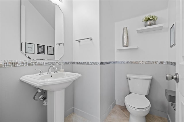 bathroom featuring sink, tile patterned floors, and toilet