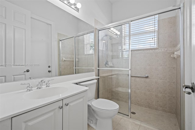 bathroom featuring a shower with door, vanity, tile patterned floors, and toilet