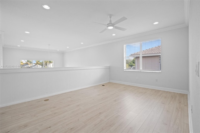 empty room featuring ceiling fan, ornamental molding, and light wood-type flooring