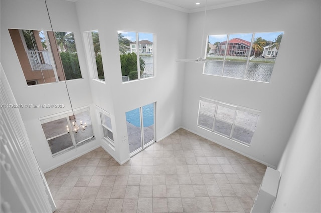 unfurnished living room with a water view and crown molding