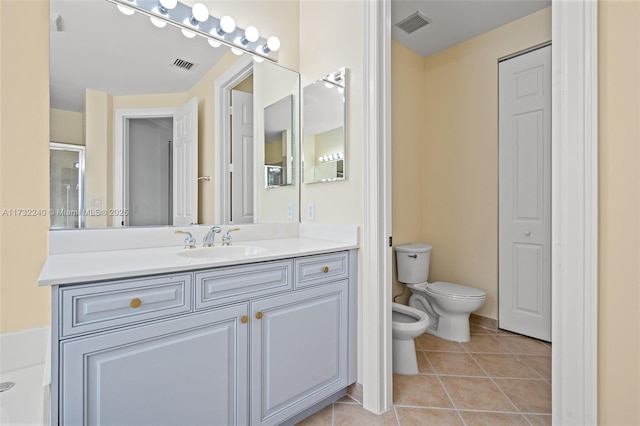 bathroom with a bidet, tile patterned floors, toilet, and vanity