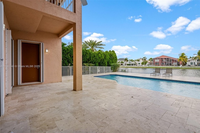 view of swimming pool featuring a patio and a water view