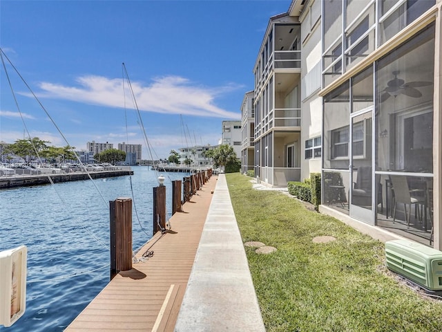 view of dock featuring a lawn and a water view