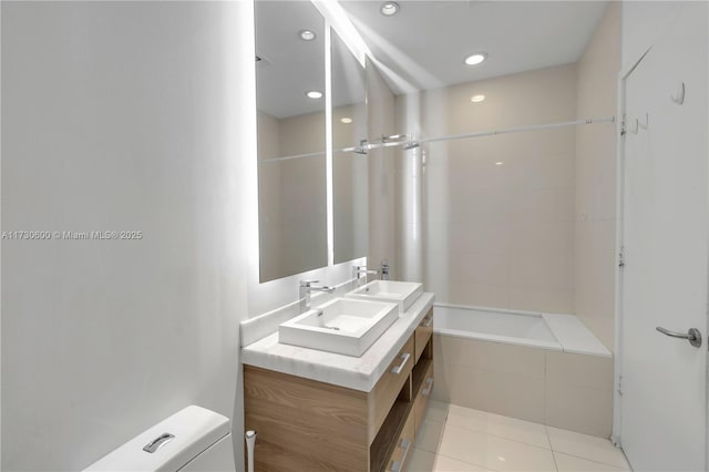 full bathroom featuring tiled shower / bath, vanity, toilet, and tile patterned flooring