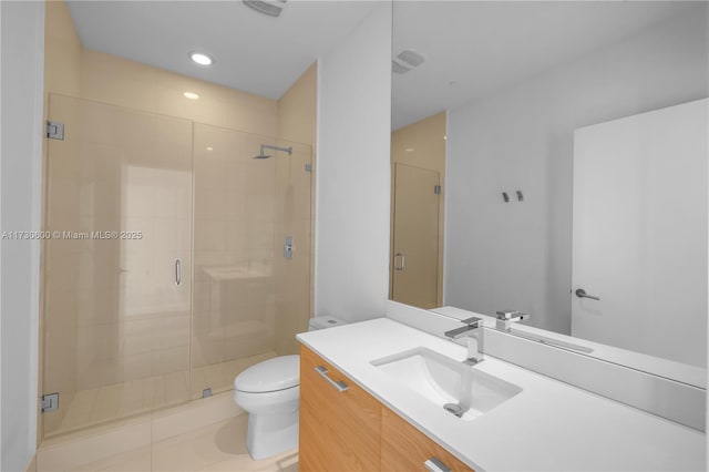 bathroom featuring tile patterned flooring, vanity, a shower with door, and toilet