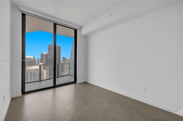 empty room with a wall of windows and concrete floors