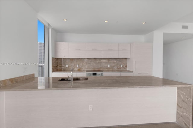 kitchen with white cabinetry, sink, and decorative backsplash