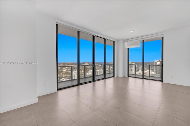 unfurnished room with a wall of windows