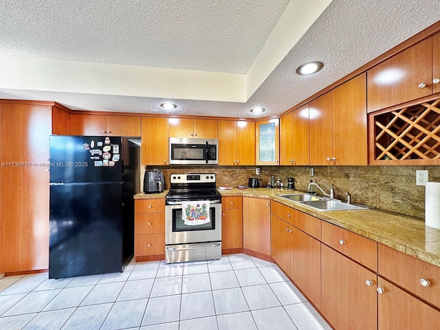 kitchen with stainless steel appliances, sink, and light tile patterned floors