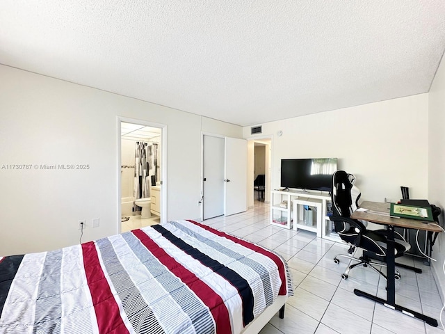 bedroom featuring a textured ceiling and light tile patterned floors