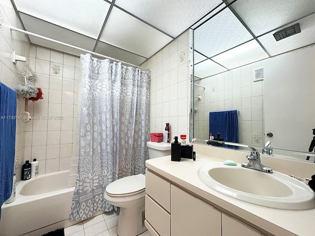 full bathroom with tile walls, vanity, toilet, tile patterned floors, and shower / bath combo with shower curtain