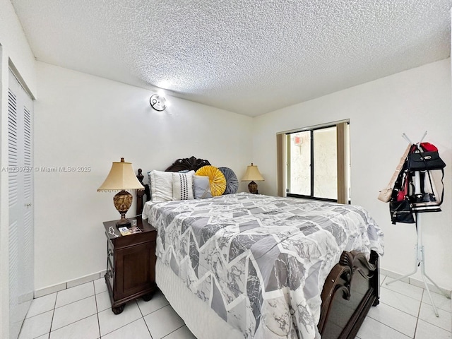 tiled bedroom featuring a textured ceiling