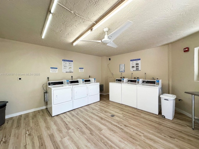 washroom featuring ceiling fan, washer and clothes dryer, light hardwood / wood-style floors, and a textured ceiling