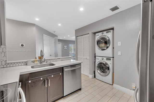 laundry room with stacked washer / dryer and sink