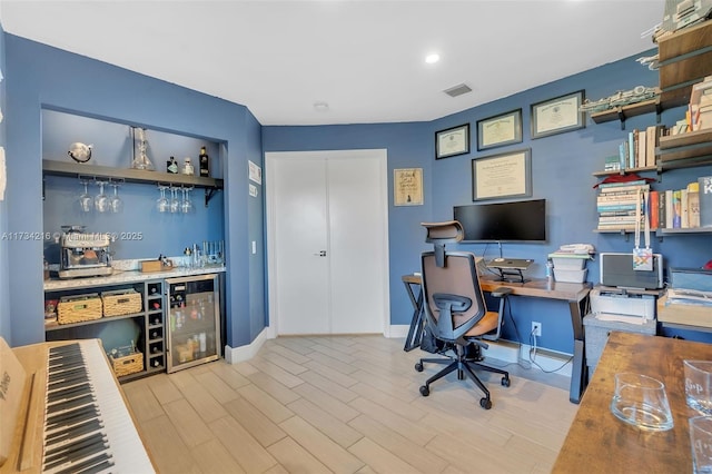 office area featuring bar, beverage cooler, and light hardwood / wood-style floors