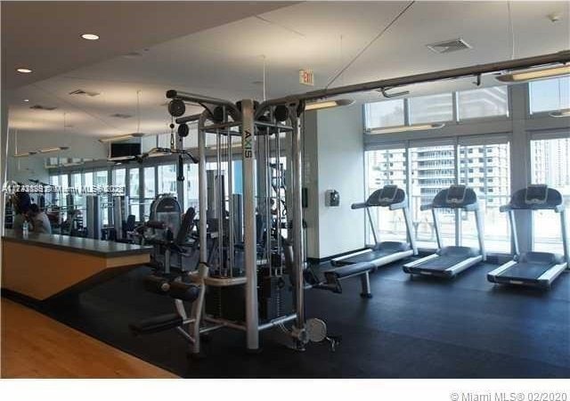 gym with a wall of windows