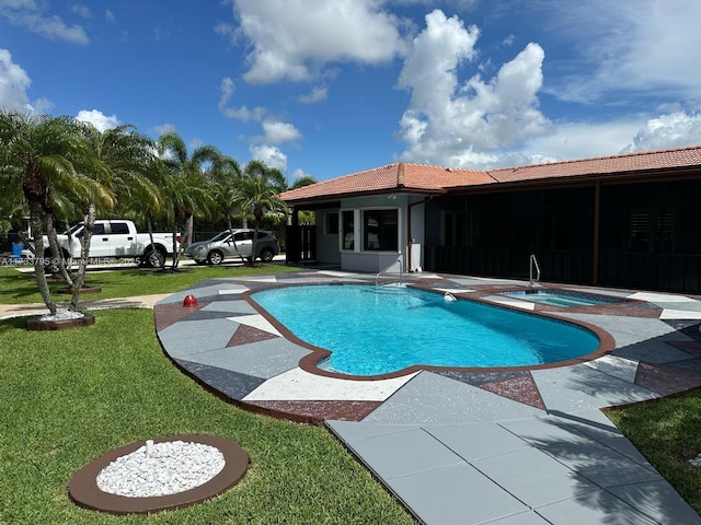 view of pool with a yard, a sunroom, a patio, and an in ground hot tub