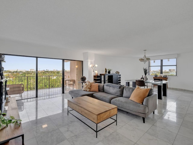 living area with marble finish floor, a wealth of natural light, and a chandelier