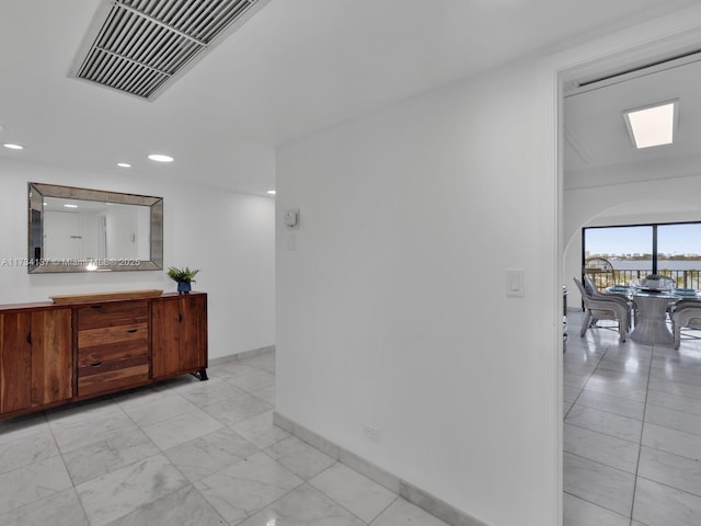 corridor with recessed lighting, visible vents, baseboards, and marble finish floor