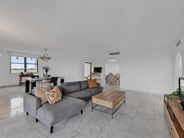 living area featuring arched walkways, visible vents, and marble finish floor