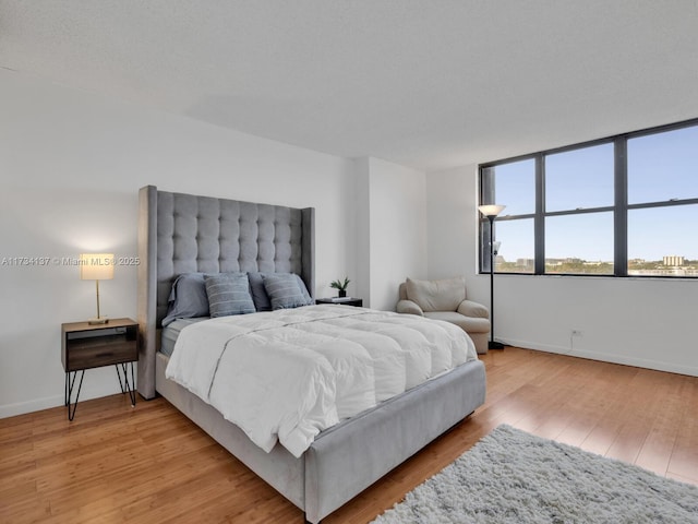 bedroom featuring light wood-type flooring and baseboards