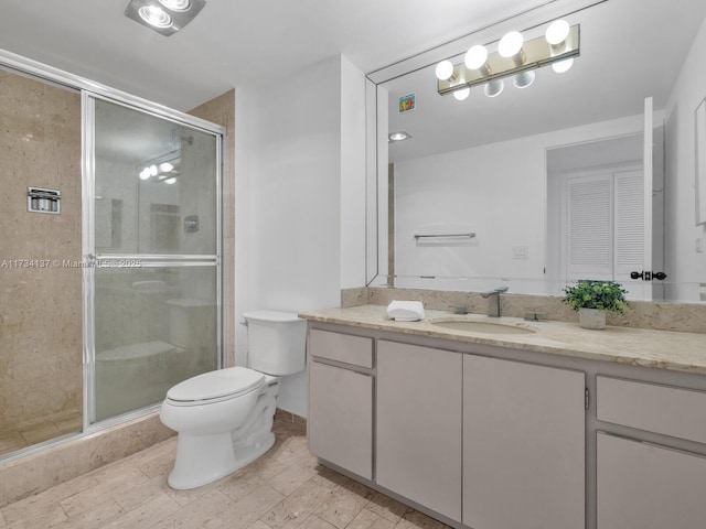 full bath featuring a stall shower, toilet, and vanity