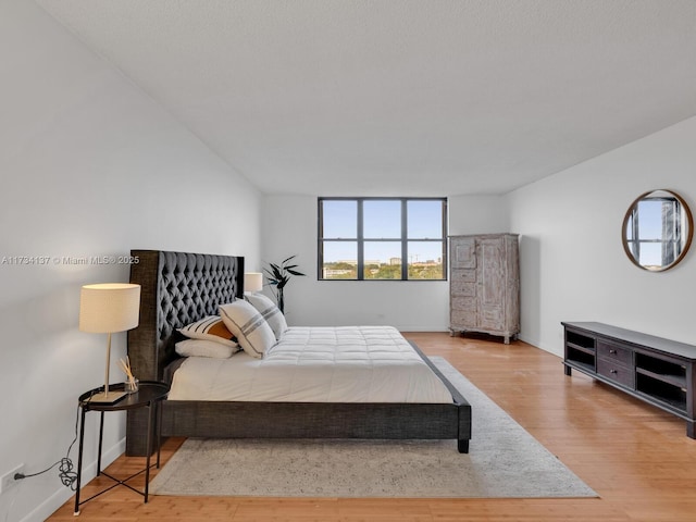 bedroom featuring baseboards and wood finished floors