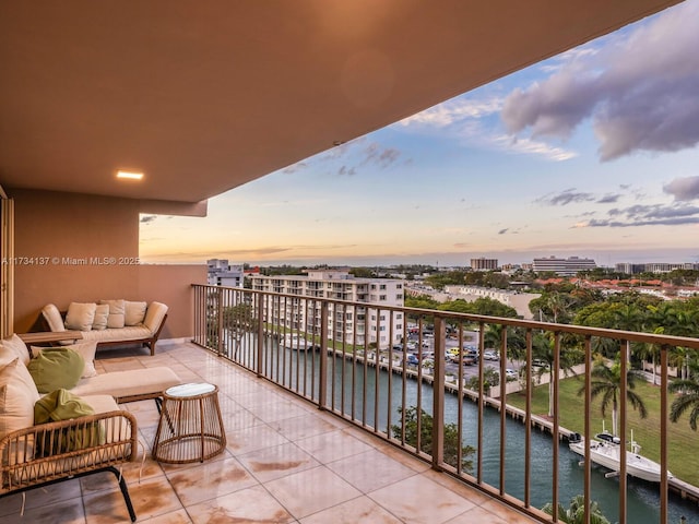 balcony at dusk with a view of city and a water view