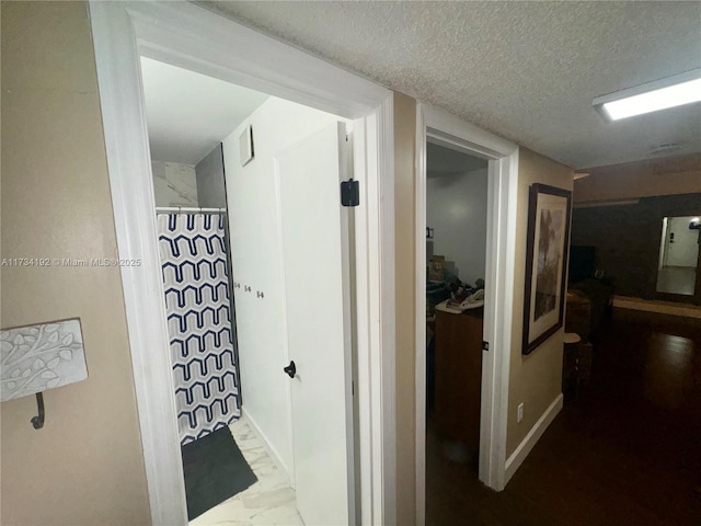 hall featuring a textured ceiling