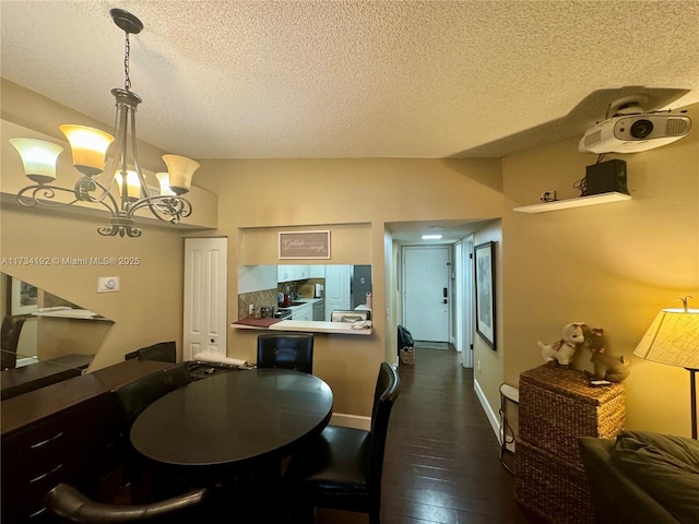 dining space with an inviting chandelier, dark hardwood / wood-style floors, and a textured ceiling