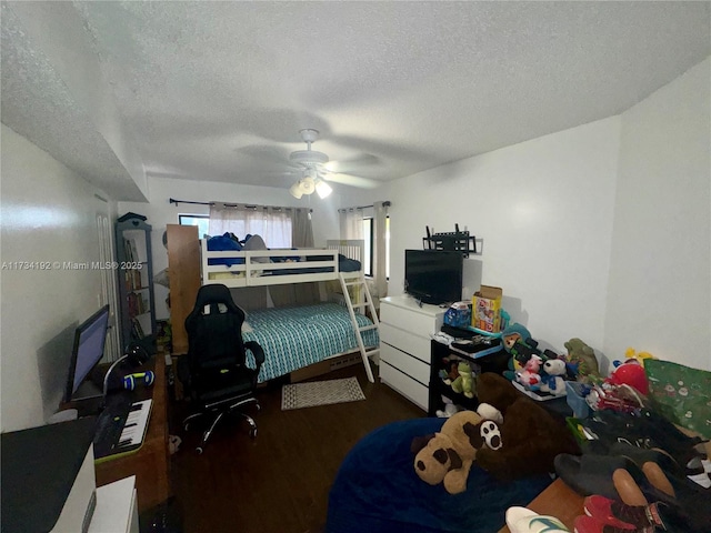 bedroom with dark wood-type flooring, a textured ceiling, and ceiling fan