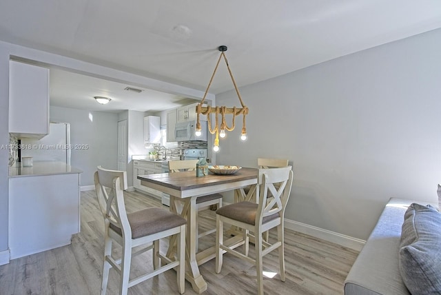 dining area featuring sink and light wood-type flooring