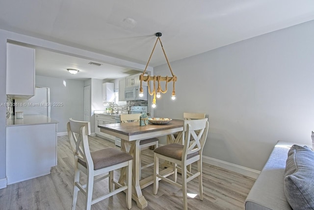 dining area featuring sink and light wood-type flooring