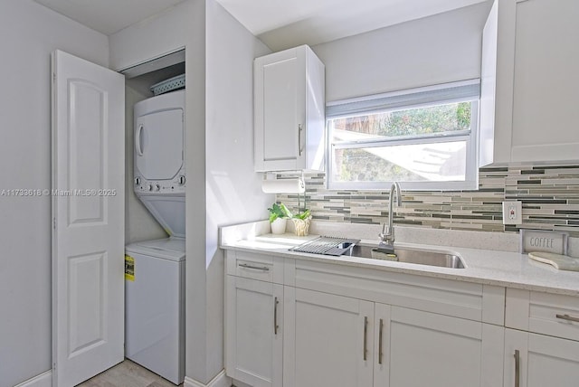 laundry room with stacked washing maching and dryer and sink