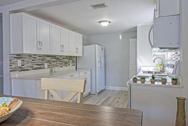 kitchen featuring tasteful backsplash, white appliances, sink, and white cabinets